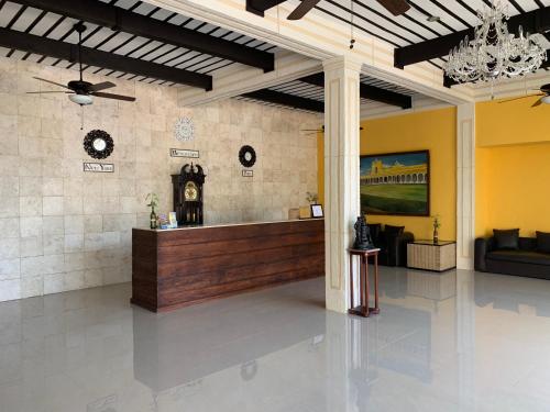 a lobby with a reception desk and a clock at Hotel Tuul in Izamal