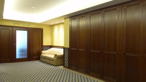 a dressing room with wood cabinets and a chair in a room at Centrum Hotel in Debrecen