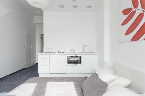 Habitación blanca con cama y cocina en Platinum Sky en Wroclaw