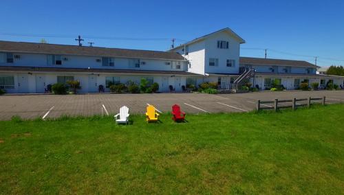 two people sitting on chairs in the grass in front of a building at Econo Lodge Inn & Suites in Saint John