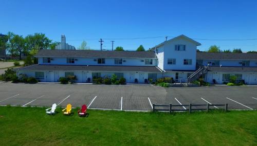 three children sitting in a parking lot in front of a building at Econo Lodge Inn & Suites in Saint John