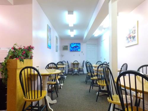 a dining room with tables and chairs and a tv at Econo Lodge Inn & Suites in Saint John