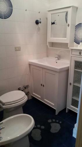 a bathroom with a white toilet and a sink at Le Chat Riant in Fenis