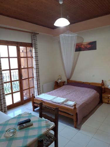 a bedroom with a bed and a table at Koutadelias rooms in Kalamos