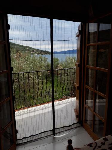 a room with a window with a view of a balcony at Koutadelias rooms in Kálamos