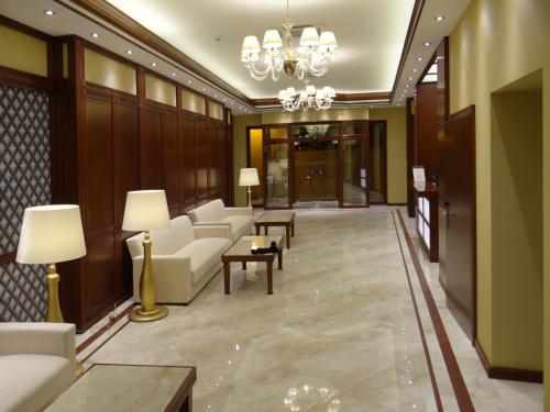 a lobby with couches and tables and a chandelier at Centrum Hotel in Debrecen