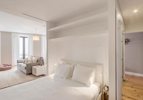 a white bedroom with a white bed and a couch at Look At Me - Serviced Lofts & Studios in Porto
