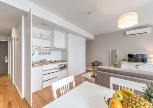 a kitchen with white cabinets and a table with fruit at Look At Me - Serviced Lofts & Studios in Porto