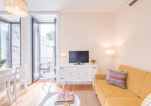 a living room with a couch and a tv at Look At Me - Serviced Lofts & Studios in Porto