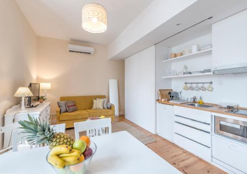 a kitchen and living room with a table with a bowl of fruit at Look At Me - Serviced Lofts & Studios in Porto