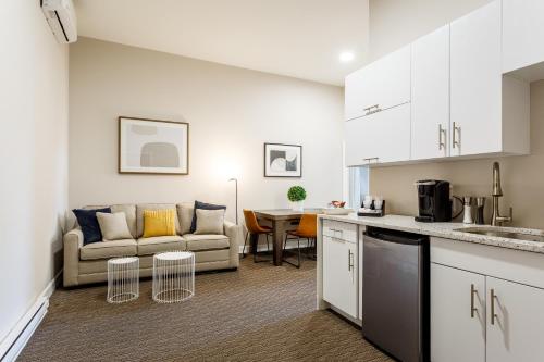a kitchen and living room with a couch and a table at Parc Avenue Lofts in Montréal