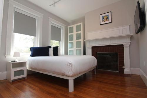 1 dormitorio con 1 cama y chimenea en Large Studio w/ Queen AND Sofa Bed..#38 en Brookline
