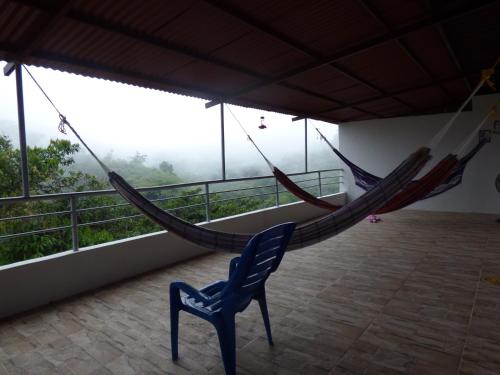 a room with two hammocks on a balcony at Hostal Alto de la Montaña in Minca