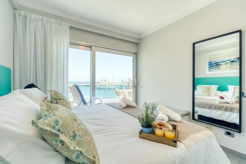 a bedroom with a white bed with a view of the ocean at Amarre Ocean in Puerto de Mogán