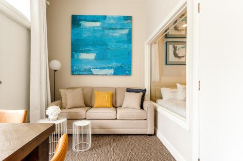 a living room with a couch and a blue painting at Parc Avenue Lofts in Montréal