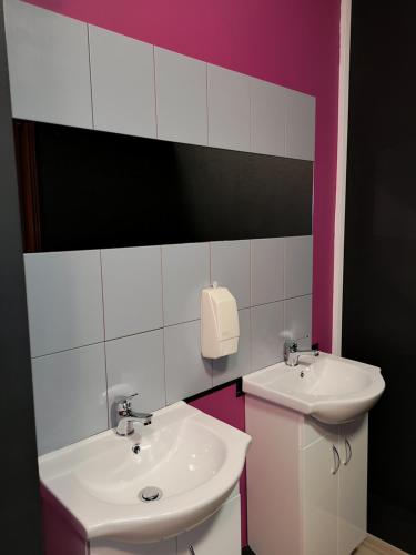 a bathroom with two sinks and a soap dispenser at DanHostel in Warsaw