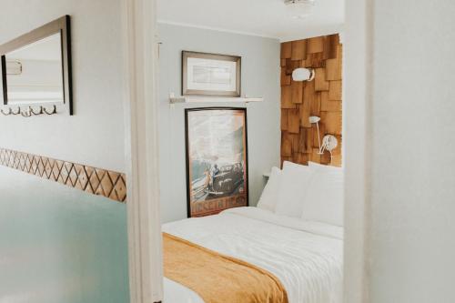 a small bedroom with a bed and a mirror at Nye Beach Condos & Cottages in Newport