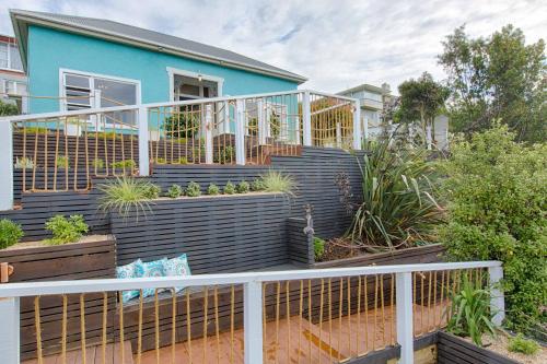a blue house with plants on a balcony at Aqua On Reed in Oamaru