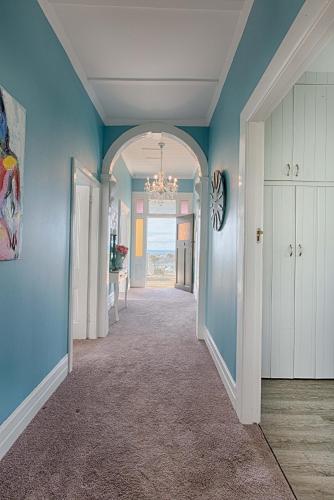 a hallway of a home with blue walls at Aqua On Reed in Oamaru