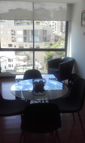 mesa y sillas en una habitación con ventana grande en Ejecutivo Vista a Quito, Cerca a la Carolina, en Quito