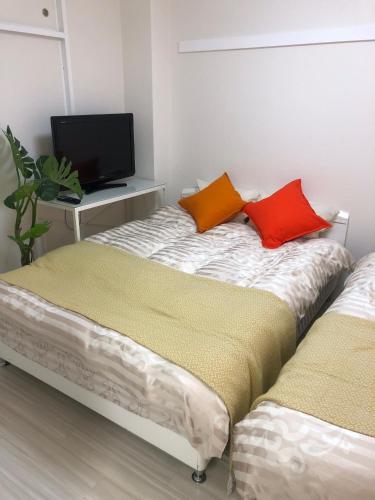 a bedroom with a bed with two pillows on it at GOLDHOUSE Shinosaka 303 in Osaka