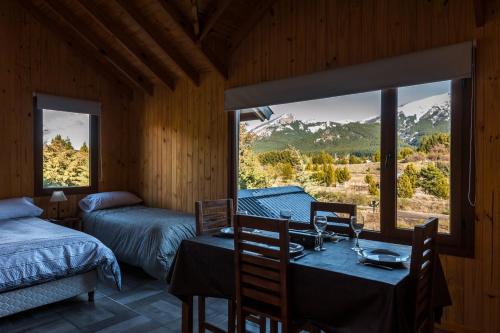 a bedroom with a table and a bed and a window at Cabañas & Apart Ruta 63 in Villa Meliquina