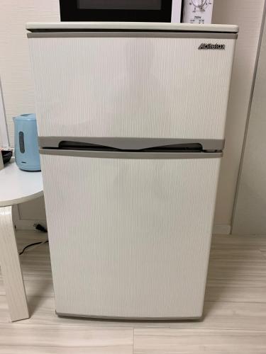a refrigerator with a microwave on top of it at GOLDHOUSE Shinosaka 303 in Osaka