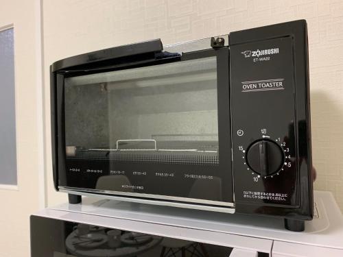 a microwave oven sitting on top of a shelf at GOLDHOUSE Shinosaka 303 in Osaka