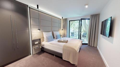 ティメンドルファー・シュトラントにあるWhite Pearl Appartment 1.07のベッドと大きな窓が備わるホテルルームです。