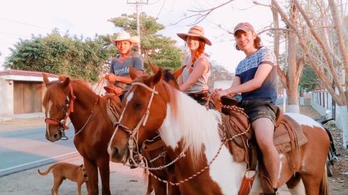 a group of people riding horses with a dog at Hostal y Camping Villa Mercedes in Tizimín