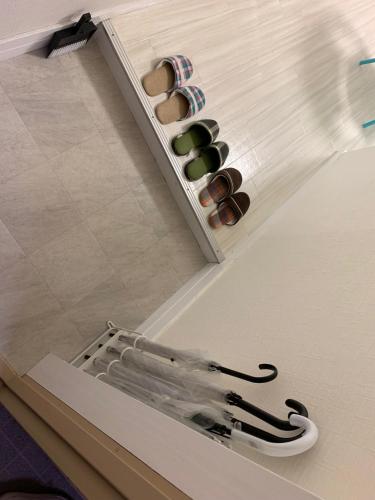 a room with a shelf with a group of shoes at GOLDHOUSE Shinosaka 303 in Osaka