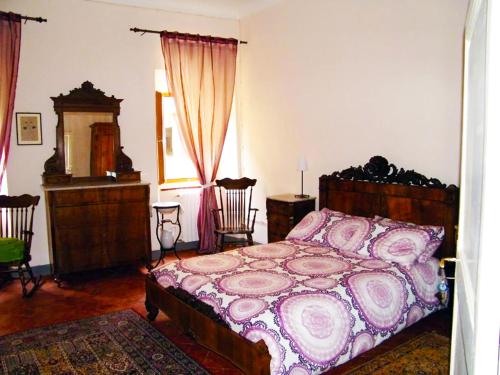 a bedroom with a bed and a dresser and chairs at B&B Il Glicine in Montefollonico