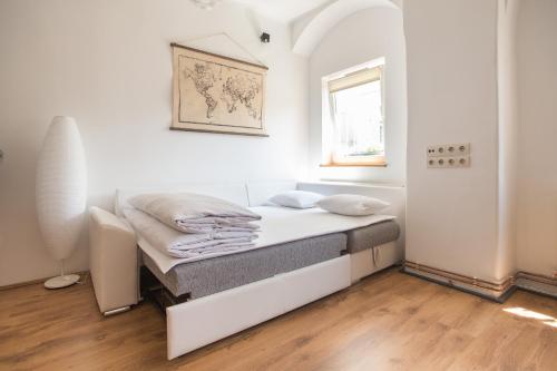 Cama en habitación blanca con ventana en Apartment Atlas, en Zagreb