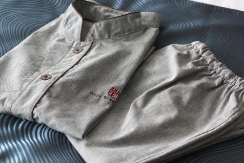 a silver jacket sitting on top of a bed at RESI STAY Mayu Grace Hotel in Kyoto