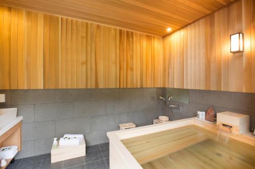 a bathroom with a bath tub and a toilet at Tomonoya Ryokan Geoje in Geoje