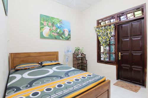 a bedroom with a bed and an open door at Batik Trinidar Homestay in Yogyakarta