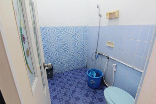 ein blaues Bad mit WC und Mülleimer in der Unterkunft Batik Trinidar Homestay in Yogyakarta