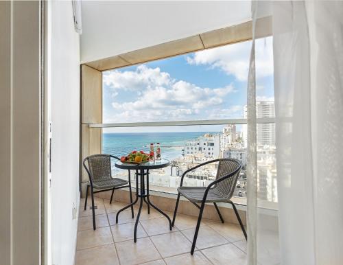 d'un balcon avec une table et des chaises et une vue sur l'océan. dans l'établissement Leonardo sea view residence, à Bat Yam