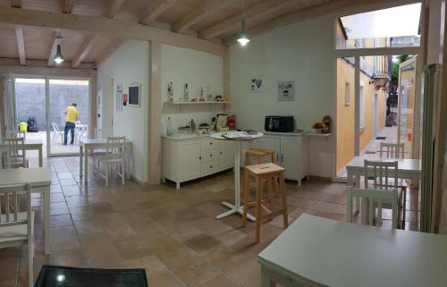 a kitchen with tables and chairs in a room at Il Daviduccio Suite in Siracusa