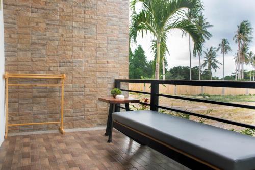 a balcony with a bench and a brick wall at Field-D House in Koh Tao