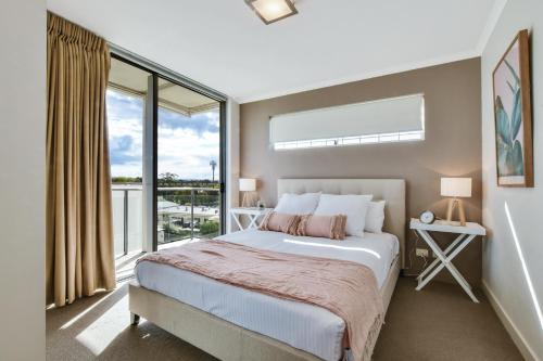 a bedroom with a bed and a large window at Horton Apartments in Maroochydore
