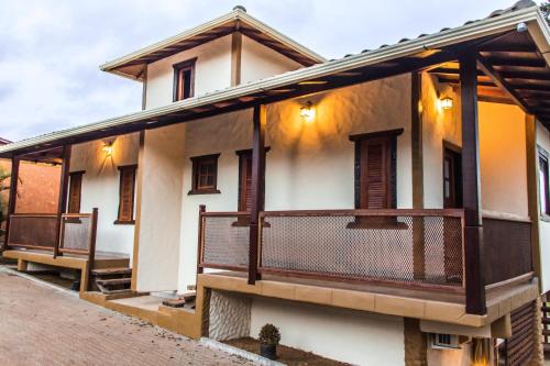 a house with a balcony on the side of it at Pé da Serra Suítes in Lavras Novas