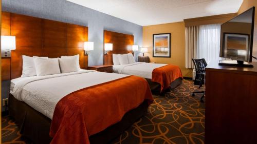 a hotel room with two beds and a flat screen tv at Best Western Plus Fresno Airport Hotel in Fresno