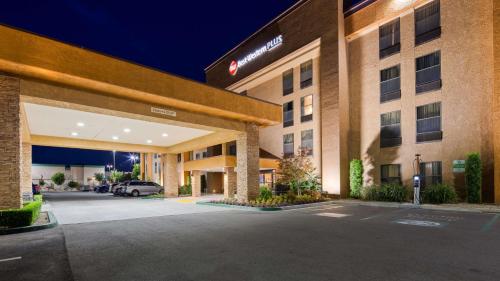a hotel with a parking lot in front of it at Best Western Plus Fresno Airport Hotel in Fresno