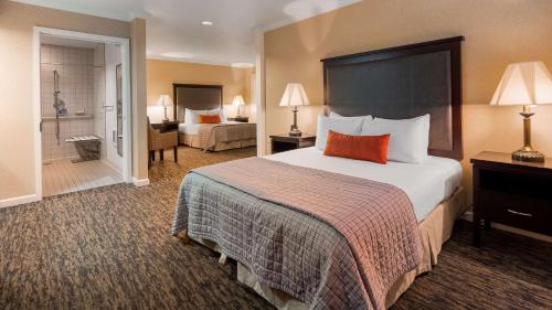a hotel room with a large bed and a bathroom at Best Western Plus Humboldt Bay Inn in Eureka