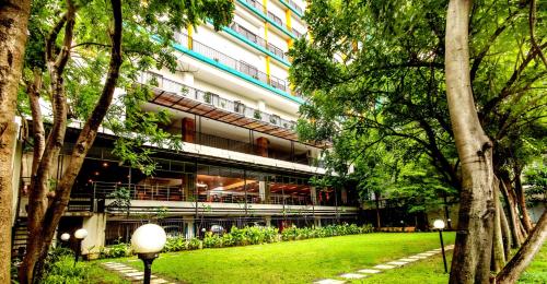 a building with a lawn in front of a building at Hotel Gren Alia Jakarta in Jakarta
