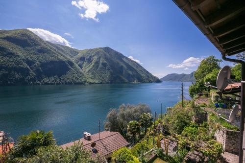 einen Blick auf einen See mit Bergen im Hintergrund in der Unterkunft Magic Gandria - Happy Rentals in Lugano