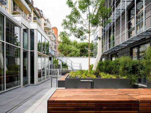 a courtyard in a building with a wooden table and benches at Mercure München City Schwabing in Munich