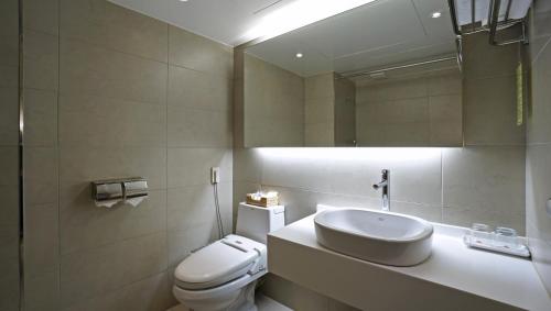 a bathroom with a toilet and a sink and a mirror at Insadong Crown Hotel in Seoul