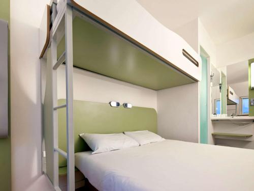 a bedroom with a bunk bed with a green wall at Ibis Budget Portsmouth in Portsmouth